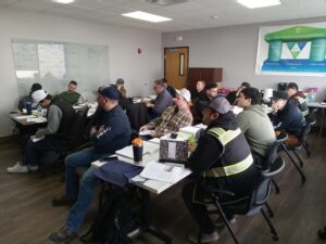 A group of people sitting at tables in front of laptops.