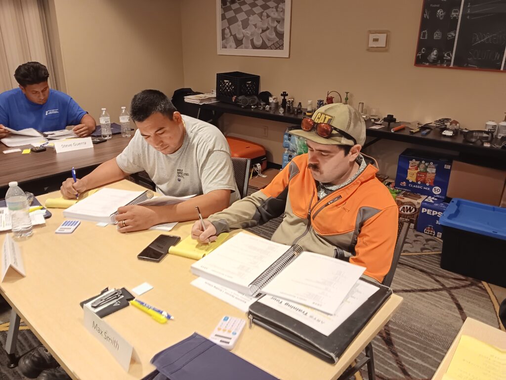 A group of people sitting at a table working on papers.