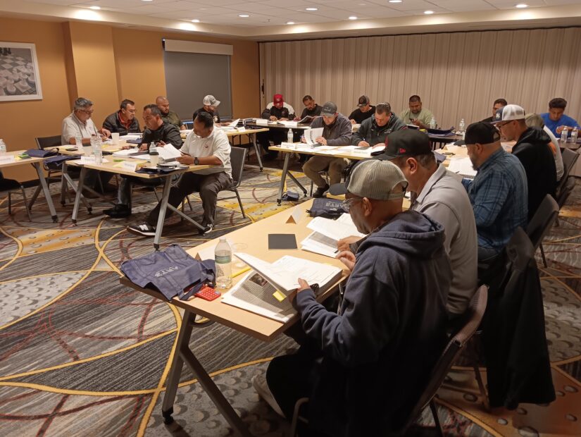 A group of people sitting at tables in front of papers.