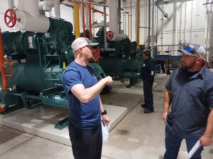 Two men in a factory talking to each other.