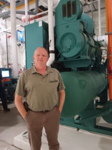A man standing in front of an industrial machine.