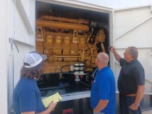 Three people standing next to a large machine.