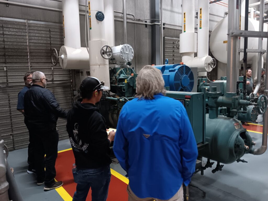 A group of people standing around in front of some machines.