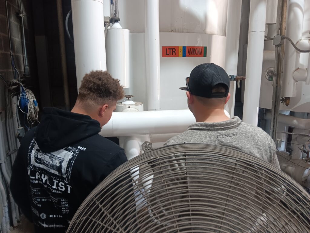 Two men sitting on a chair looking at each other.