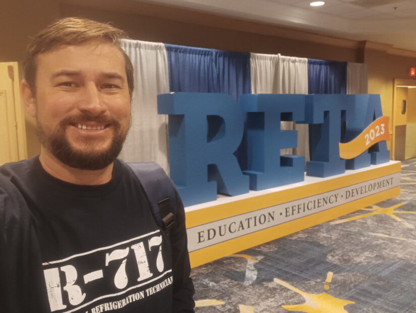 A man standing in front of the reit logo.