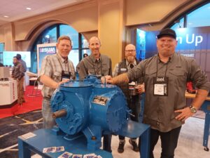 Four men standing around a blue machine