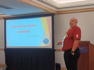 A man standing in front of a projector screen.