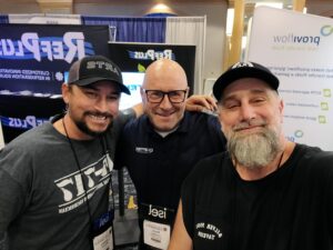 Three men posing for a picture at an event.