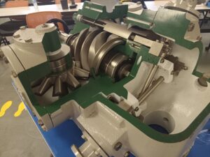 A green and white machine with many gears on it