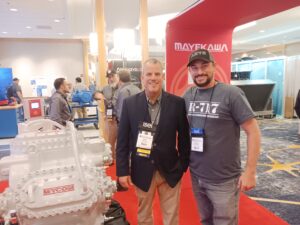 Two men standing in front of a red and white display.