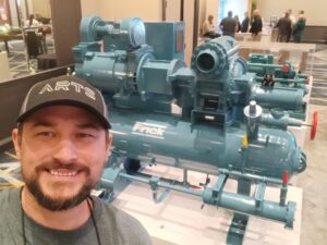 A man standing in front of some water pumps