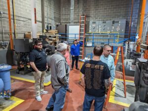 A group of people standing around in an industrial building.