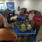 A group of people standing around a table.