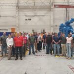 A group of people standing in front of a blue sculpture.