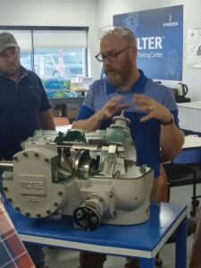 A man is looking at an engine on the table.