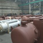 A warehouse filled with large metal tanks.