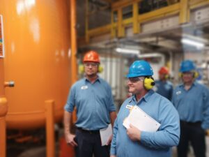 A group of men in hard hats and blue shirts.