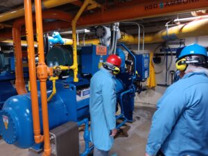 A group of people in blue jackets and hard hats.