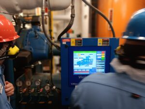 A person is looking at the screen of an industrial machine.