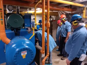 A group of people standing around a blue machine.
