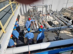 A group of people standing around in front of pipes.