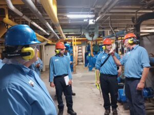 A group of men in blue shirts and hard hats.
