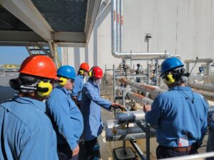 A group of people in blue shirts and hard hats.